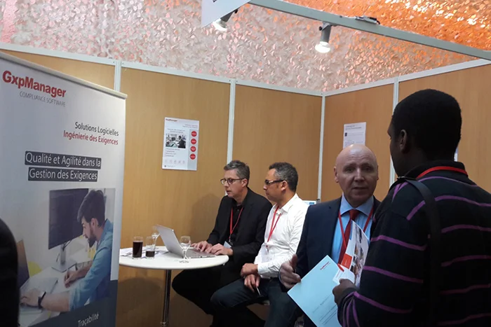 People discussing in front of a stand during the JFIE 2016