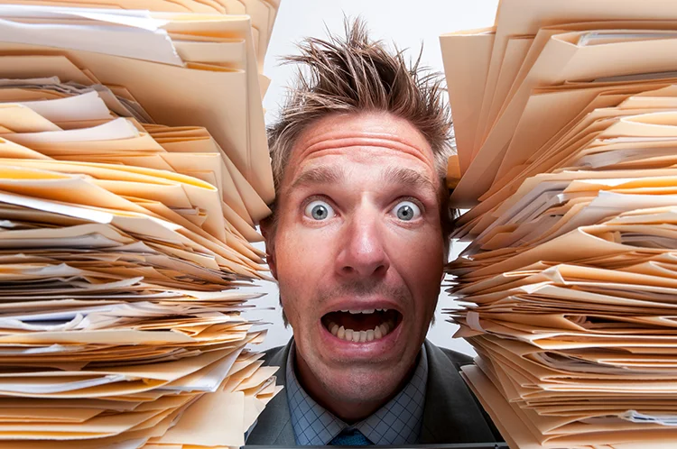 Visual representing a man surrounded by piles of documents