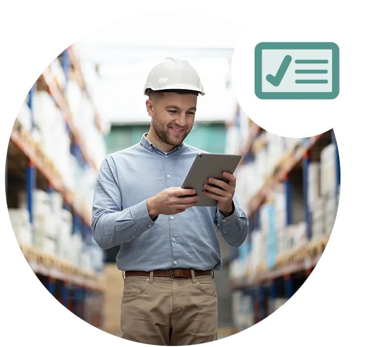 photo of a man wearing a hard hat looking at a tablet with a warehouse management application